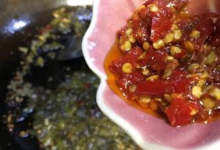 酸菜炒出香味后倒入酸辣椒，继续炒出香味