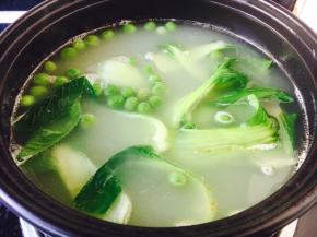 砂锅里放入1碗高汤，高汤煮开后放入豌豆煮熟，再放入小油菜。