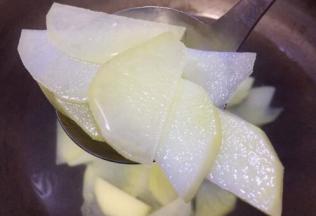 铁锅烧水把洗好的土豆片稍煮至断生，即土豆片变透明就捞起