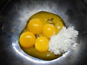 蛋黄蛋白分离，在蛋黄中加入细砂糖，用手动打蛋器搅打均匀。