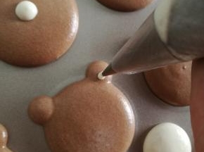 剩一点白色糊换最小号圆型花嘴做熊的耳朵和鼻子。还剩的话就挤几个小迷你马卡龙。