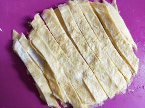 鸡蛋饼煎好放凉后切成长条。