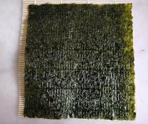 卷帘铺上紫菜，粗糙的一面朝上。