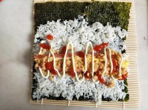 挤上番茄酱和沙拉酱，没有米饭的那一边抹一点水，便于卷的适合黏合。