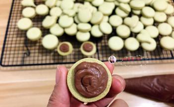 剪个小口，将巧克力馅挤在马卡龙上