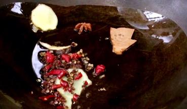 锅烧热油，放入姜片、卤料、干辣椒、少许花椒爆香