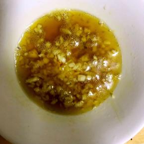 7.锅中热油，油热后放入几颗花椒粒炸制花椒油，然后将花椒挑出，趁热将油倒入蒜末碗中