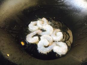 炉灶上置不粘锅，待锅微热时放入约30g的炒菜油，待油5～6成热的时候放入腌制好的虾仁。