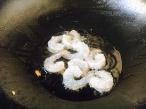 炉灶上置不粘锅，待锅微热时放入约30g的炒菜油，待油5～6成热的时候放入腌制好的虾仁。