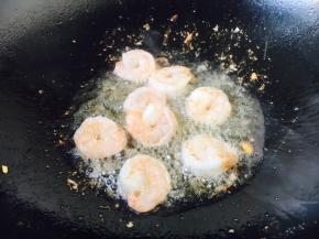 刚放入虾仁时先别翻炒，当离火晃动锅时，虾仁能滑动，不粘在锅上时即可翻炒，当虾仁颜色变成粉红色就盛出来。