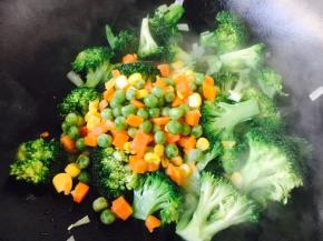 放入豌豆、胡萝卜丁、玉米粒一起煸炒。