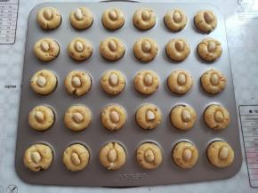 在小酥饼上轻轻按一下，放上一颗花生