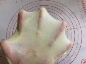 检视一下出膜情况，面团能拉出透明且有弹性的手套状薄膜，用手捅破薄膜，呈现光滑的圆形即可。