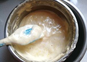 接着把先前保温好的黄油液体淋在刮刀上，让液体流在蛋糊表面；