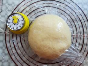 面团取出轻轻按压排气，收圆面团，盖上保鲜膜松弛15分钟