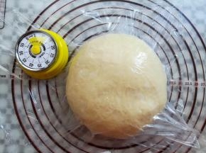面团取出轻轻按压排气，收圆面团，盖上保鲜膜松弛15分钟
