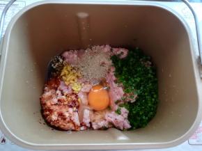 把猪肉泥，鸡蛋，香葱，生姜，生抽，胡椒粉放入面包桶里