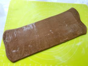 将收口处朝下，撒点干粉，擀成长条，长度是原来的两倍半