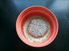 取一小团紫薯泥，按成圆形，蘸上芝麻。