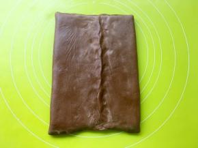 将两侧的可可面片对折，包裹上黄油，捏紧四周收口