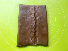 将两侧的可可面片对折，包裹上黄油，捏紧四周收口