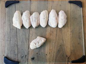 先把鸡翅正反两面划上几刀，使腌制入味