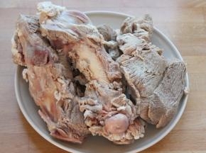 将泡出血水的肉和骨放入清水中煮开2-3分钟，煮出血污，然后将水倒掉，肉和骨清洗干净。
