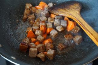 倒入葱姜料酒、生抽、蚝油、白砂糖、盐翻炒均匀