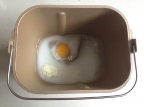 水、鸡蛋、糖、盐和奶粉放入面包桶里