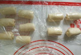 从下往上卷起来，盖保鲜膜松弛15分钟。