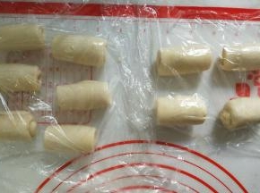 从下往上卷起来，盖保鲜膜松弛15分钟。