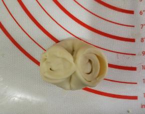 将松弛好的面团对折，两头对捏。