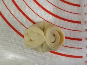 将松弛好的面团对折，两头对捏。