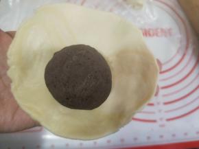 包入一个蛋黄豆沙馅，收口朝下放入烤盘。
