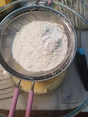 称量好的低粉跟泡打粉过筛加入蛋液内，拌匀。