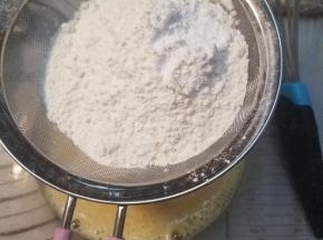 称量好的低粉跟泡打粉过筛加入蛋液内，拌匀。