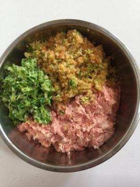 挤干的萝卜丝和葱用料理机搅打碎，放进装肉泥的盆中。