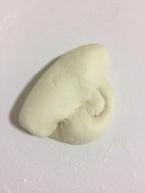 案板上撒少许面粉，把发酵好的面团取出来排气，反复多揉几下，揉到位，大约揉200下左右，这样做出来的小笼包才表面光滑，宣软。