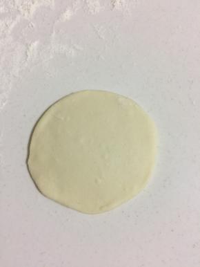 取一个面团，揉圆，擀成中间厚，两边薄的面片。