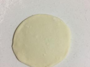 取一个面团，揉圆，擀成中间厚，两边薄的面片。