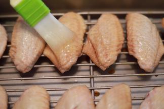 将蜂蜜和油倒入一个小碗内，拌匀，均匀的刷在鸡翅的两面