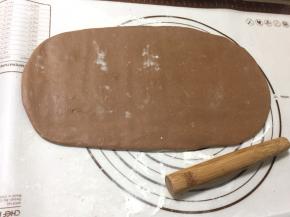 冰箱取出可可面团，用擀面杖尽量擀成规整长方形，能放下黄油