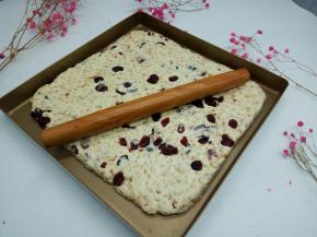 做好的牛轧糖放不粘烤盘，用擀面杖擀平整