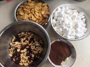 准备材料。坚果蔓越莓放一起。奶粉可可粉一个碗。黄油放平底锅里