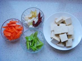 豆腐切块（约0.6CM厚），胡萝卜、青椒、姜蒜切片，辣椒、葱切小段。