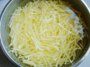 土豆切细丝入凉水中淘洗几遍冲去淀粉，水变清澈就可以了。
