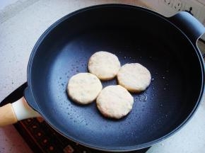 炒锅里倒入少许食用油，饼胚在手掌里按扁放入锅中。
