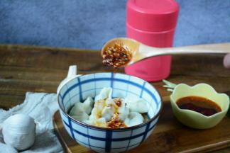 熟透的饺子捞出装碗中，加入辣椒油拌均匀。