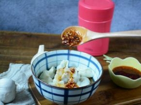 熟透的饺子捞出装碗中，加入辣椒油拌均匀。