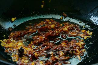 接着加入火锅料，豆瓣继续翻炒出香。